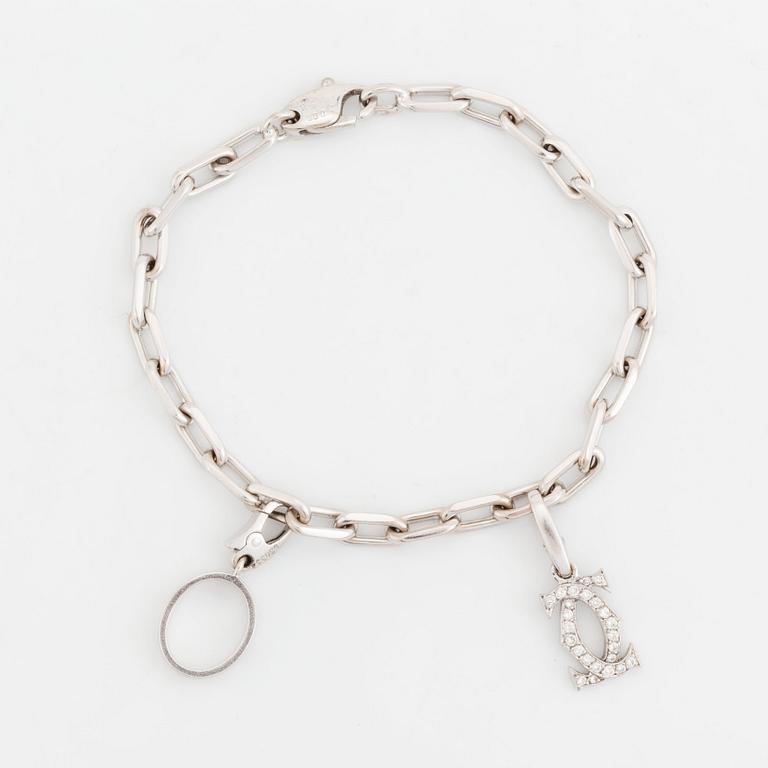 An 18K white gold Cartier "Spartacus" bracelet with two charms.