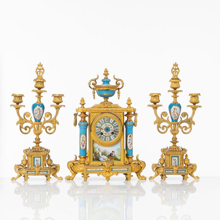 A French Louis XVI-style mantel clock and a pair of candelabra, late 19th Century.
