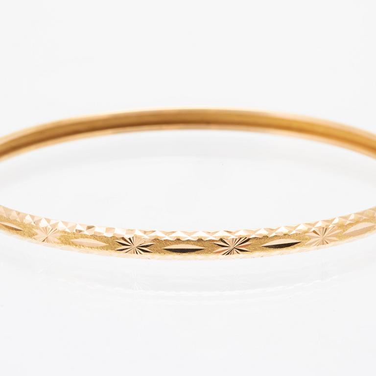 A pair of 18K gold bracelets for children.