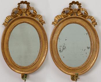 A pair of late Gustavian one-branch giltwood girandole mirrors, Stockholm, circa 1800.