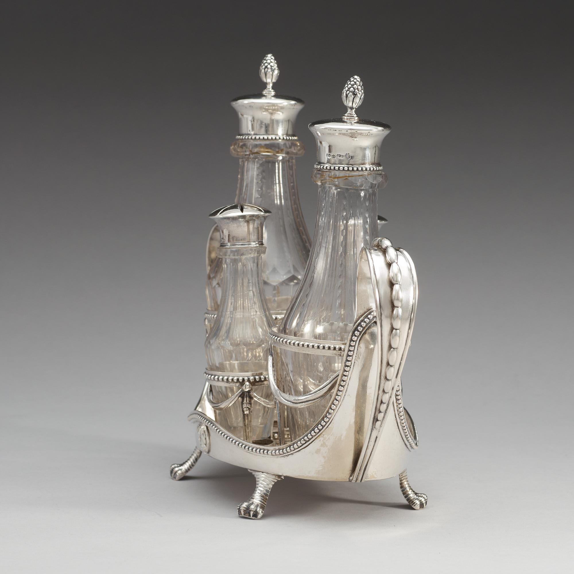 BORDSSURTOUT för fyra flaskor, silver, gustaviansk,  Stephan Westerstråhle, Stockholm 1791. Tot vikt ca 1049g.