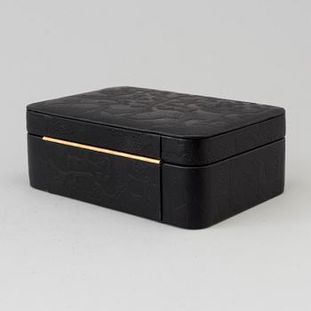 SMYCKESKRIN, präglat mönster "Aristidia" i svart skinn, Firma Svenskt Tenn, 2000-tal.
