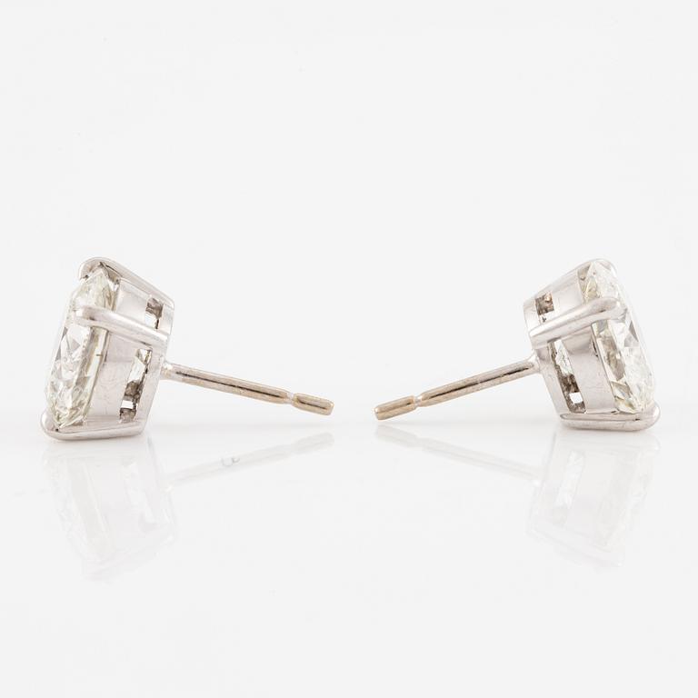 A pair of earrings in 18K white gold set with two round brilliant-cut diamonds.