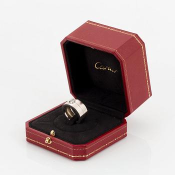 A Cartier 18K white gold ring set with a round brilliant-cut diamond.