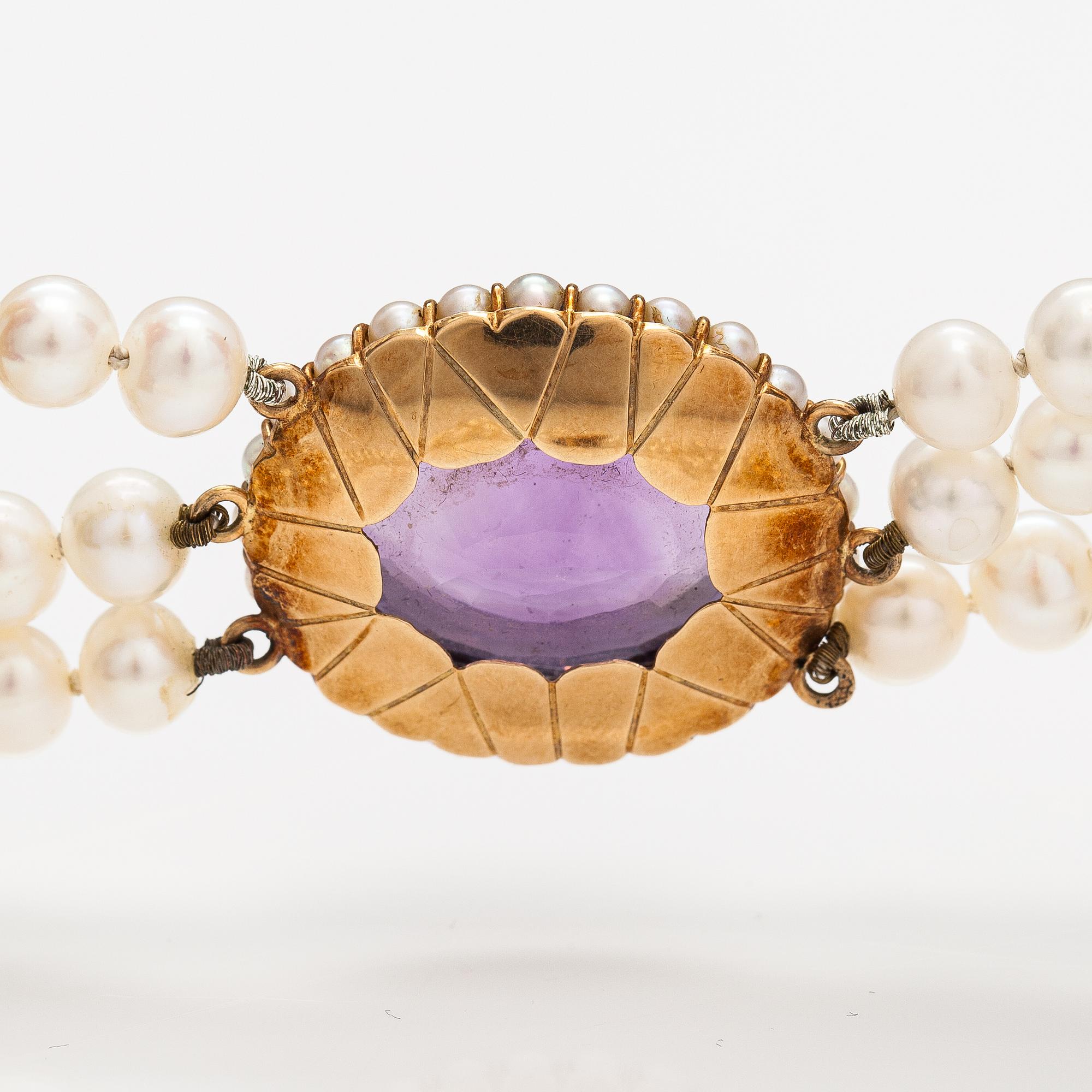 A three-strand cultured pearl collier with an amethyst and 14K gold.