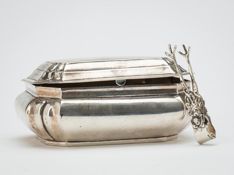 SOCKERSKRIN, Senbarock-stil, samt TÅNG, silver. 1900-tal. Total vikt ca 430 g.