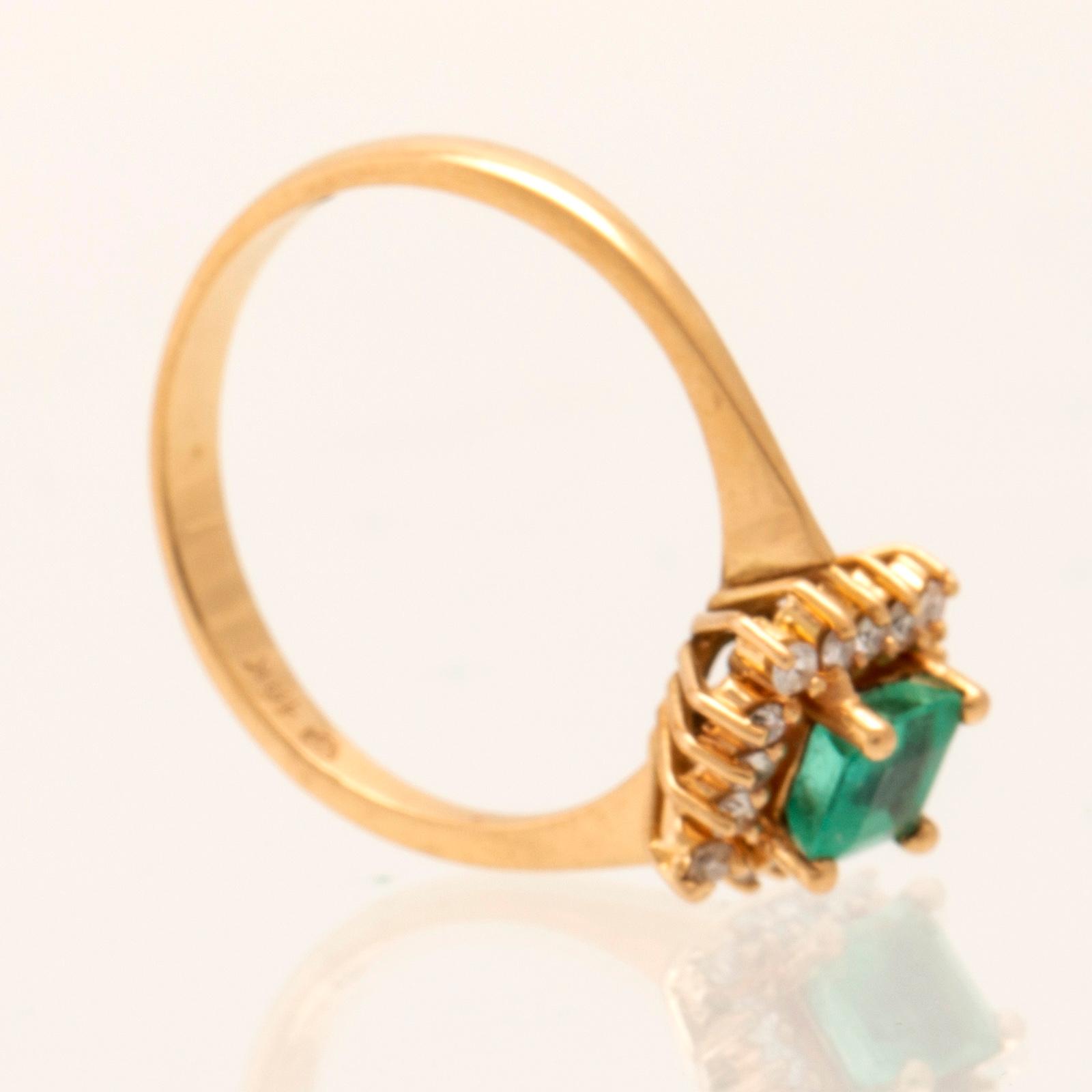 Ring in 18K gold with a step-cut emerald and round brilliant-cut diamonds.