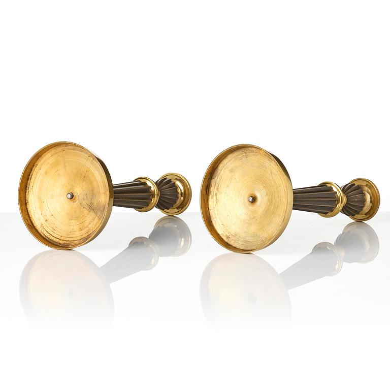 A pair of French Empire patinated and ormolu candlesticks, early 19th century.