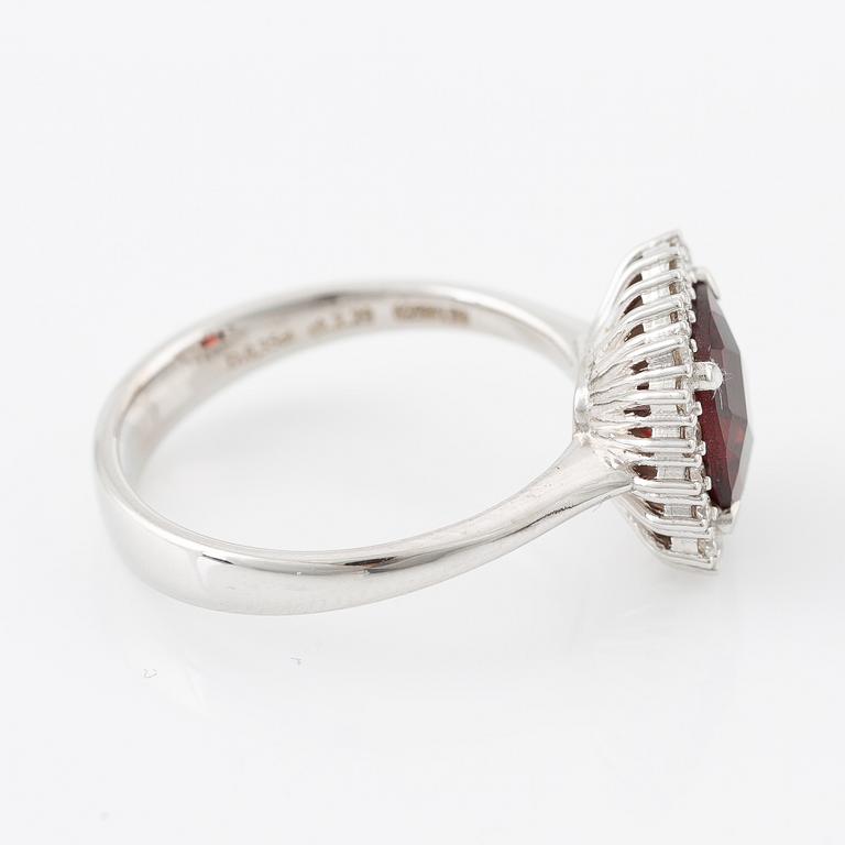 Ring in 18K gold with a faceted garnet and round brilliant-cut diamonds.