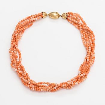 A 6-strand pearl collier with coral pearls and an 18K gold clasp.