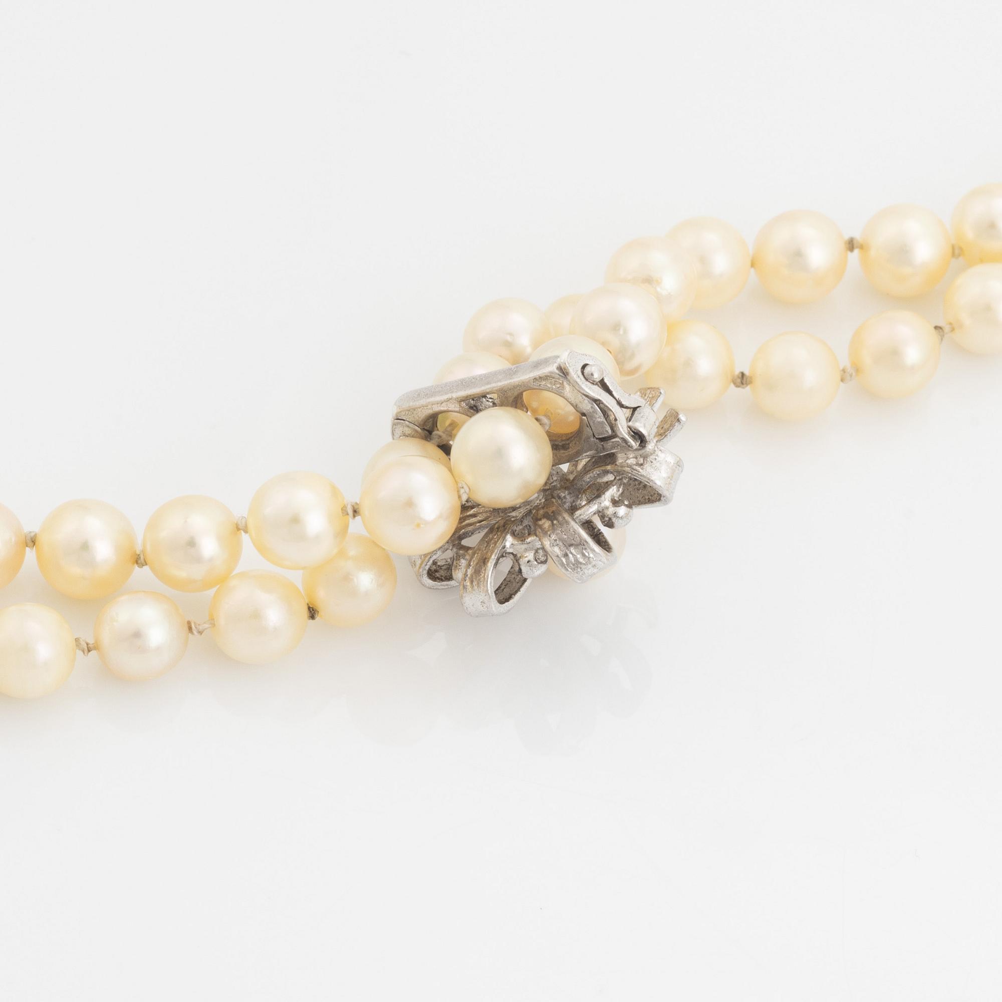 A cultured pearl necklace with silver divider.
