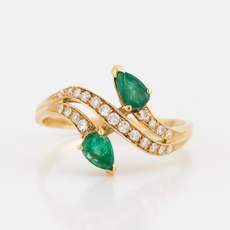 A ring set with pear-shaped emeralds and eight-cut diamonds.