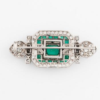 An 18K white gold Marchak art deco brooch set with step-cut emeralds.