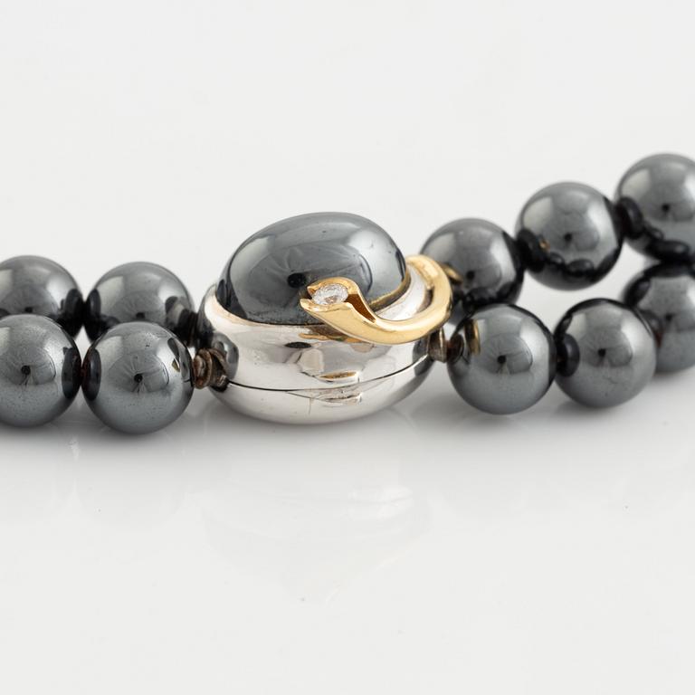 Ole Lynggaard. 2 rows of hematite beads with a clasp in 14K white gold and gold with a brilliant-cut diamond.