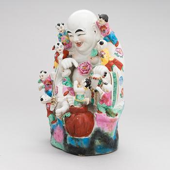 A Chinese porcelain laughing buddha with children, the 20th century.