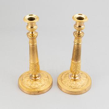 A pair of french gilt bronze candle holders, around 1820.