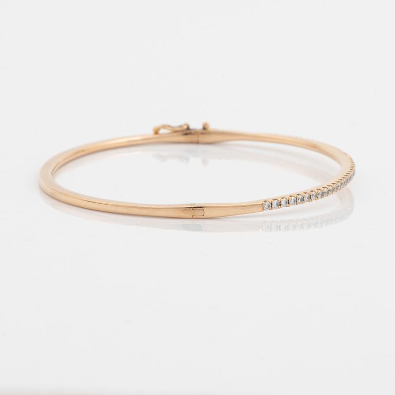 An 18K rose gold bangle set with round brilliant-cut diamonds.