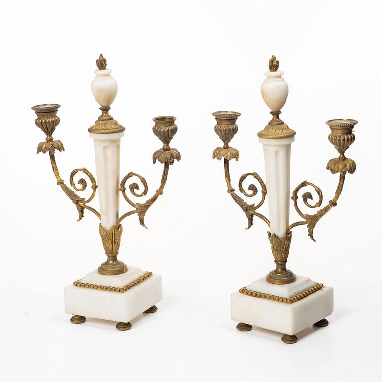 A Louis XVI-style mantle clock and a pair of candelabras. Early 20th century.