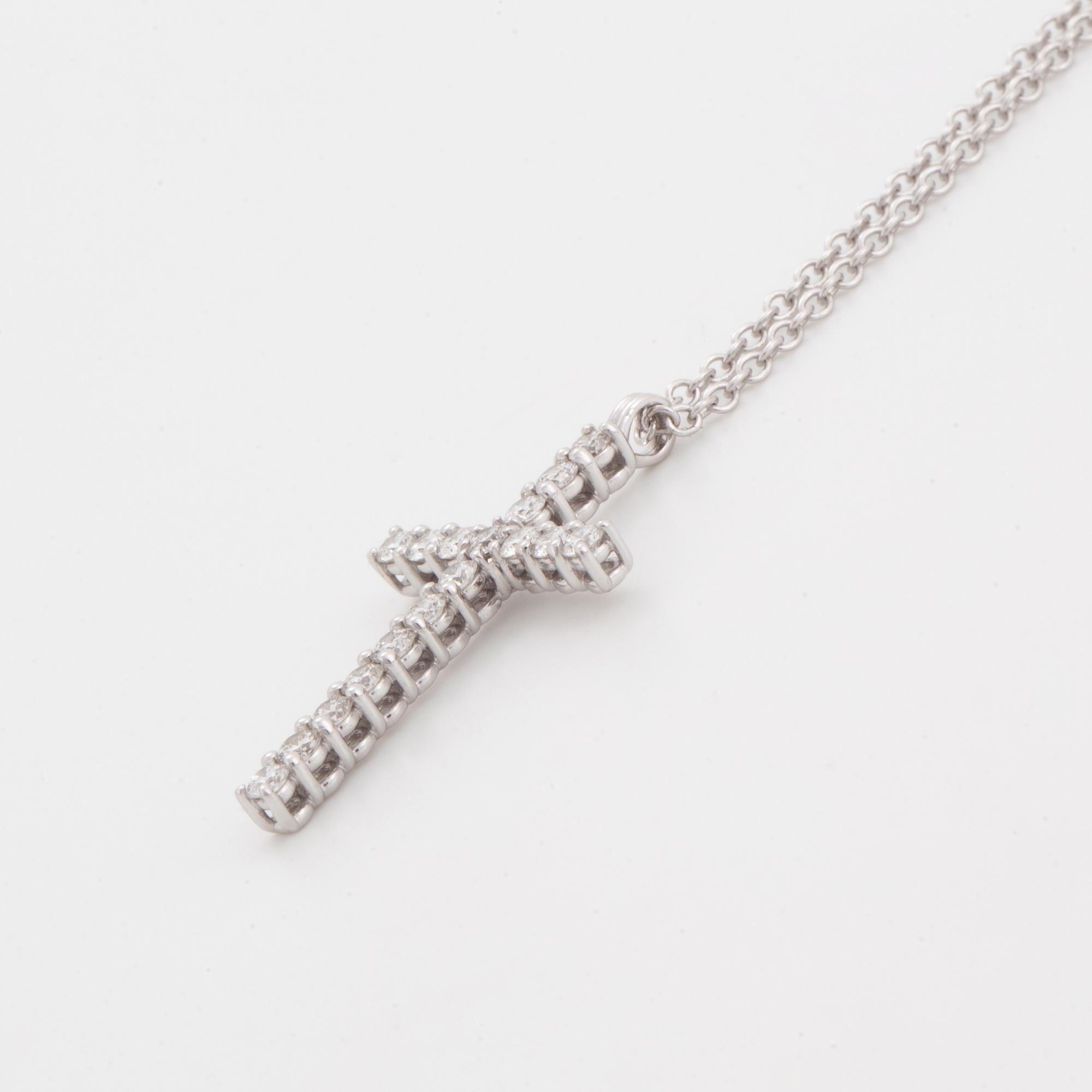 Brilliant-cut diamond cross pendant.