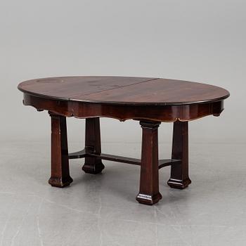 A late 19th century dining table with ten chairs and five extension leaves.