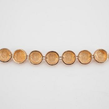 CHRISTIAN DIOR, a gold colored metall braclet with decorative glass stones.