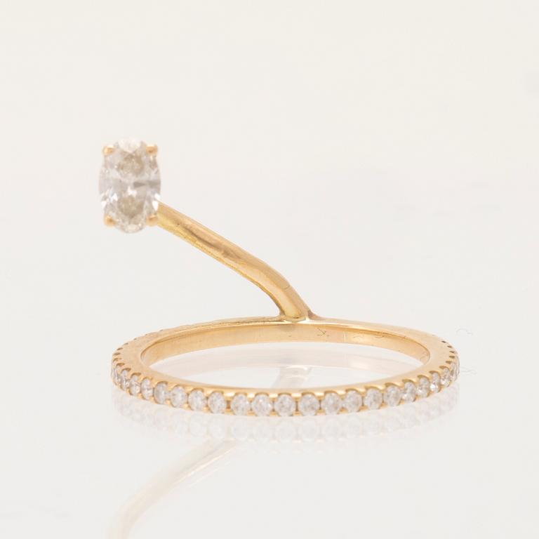 An 18K gold ring set with an oval cut and round brilliant cut diamonds by LWL Jewelry.