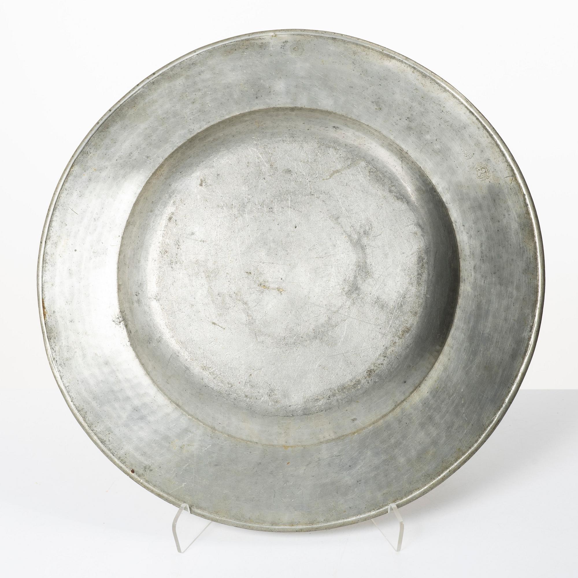 An English baroque pewter charger, dated 1672.