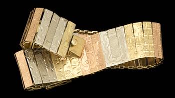 A tricoloured gold bracelet with flower motifs.