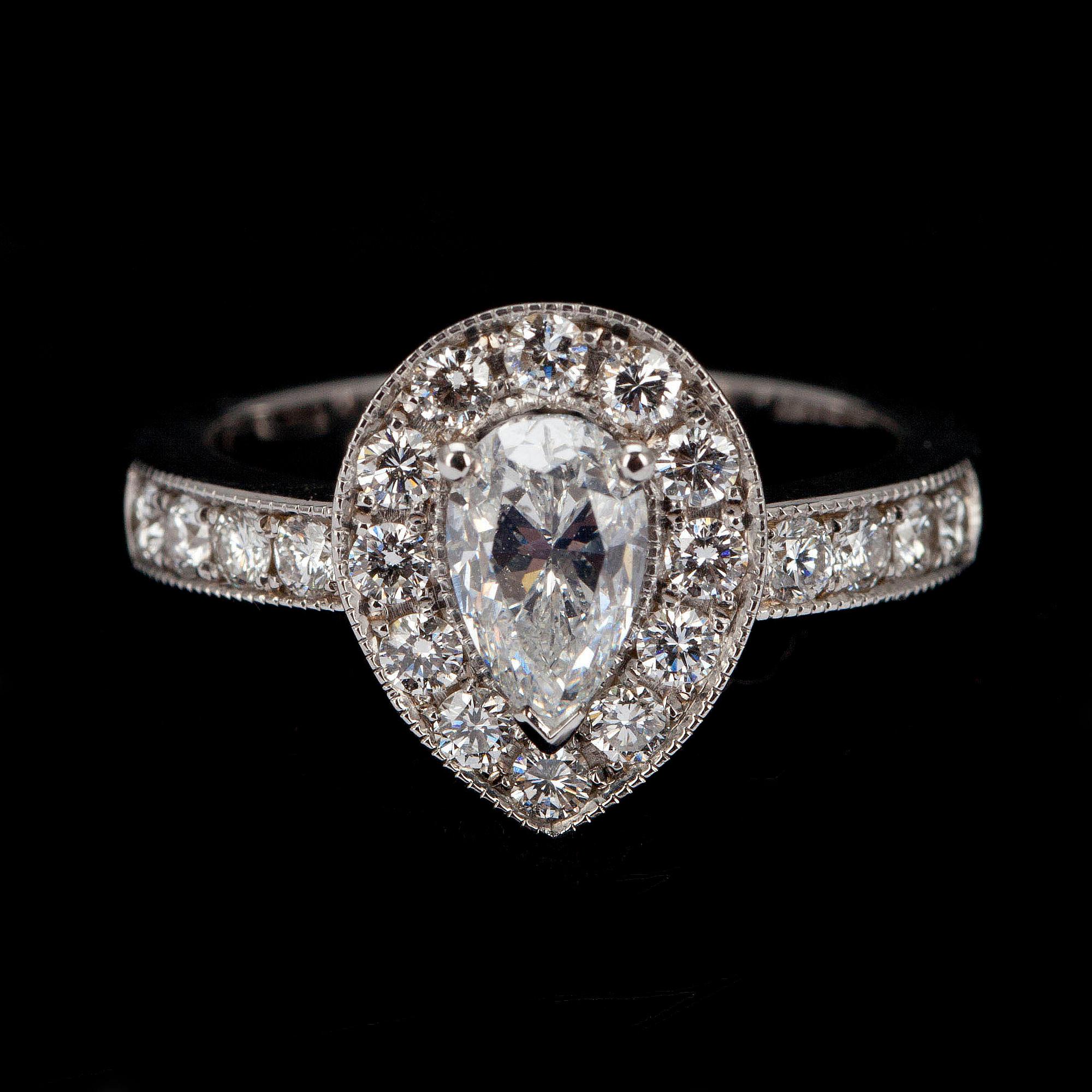 RING, vitguld 18K, mittstenen droppslipad diamant 1,01ct, sidostenar tot. 0,65ct. G/VS. Intyg 220.