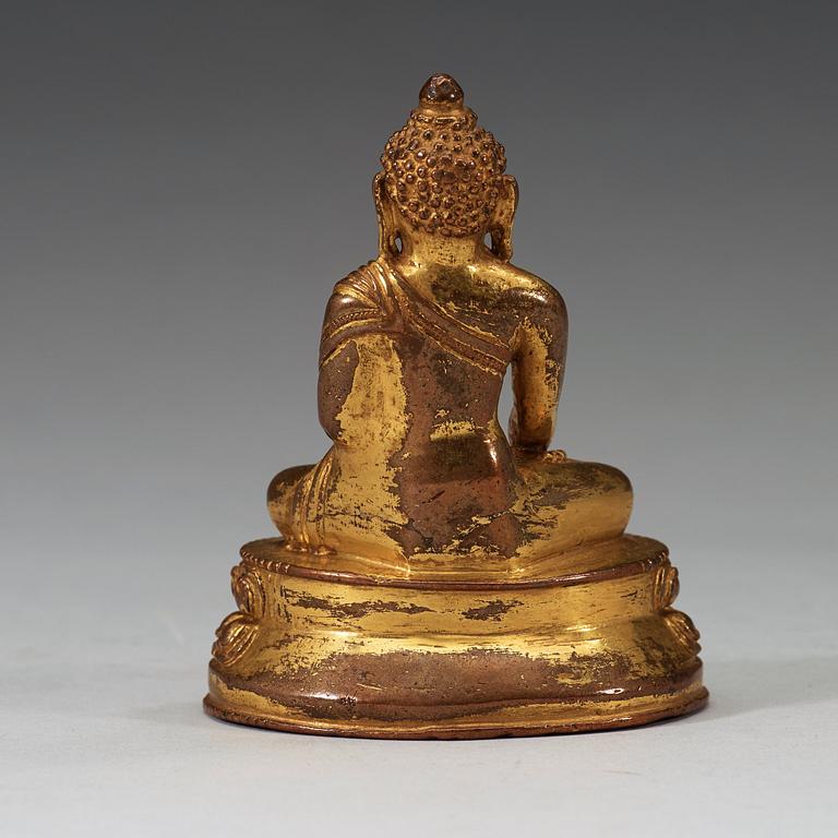 A gilt Tibetan bronze figure of Buddha, 16th Century or older.