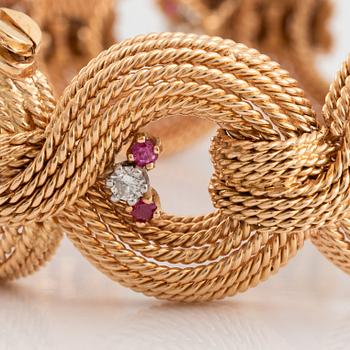 An 18K gold bracelet set with round brilliant-cut diamonds and rubies.