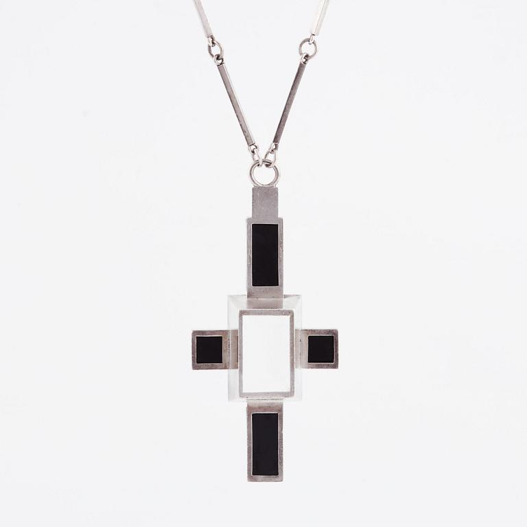 Wiwen Nilsson, hängsmycke i form av ett kors i sterlingsilver med fasettslipad bergkristall och onyx, Lund 1938.