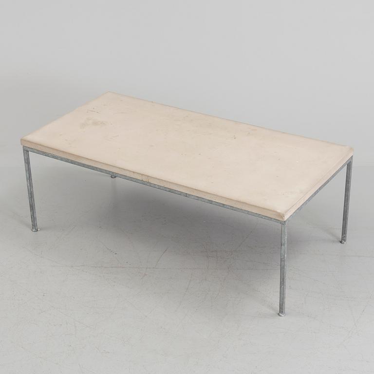 A modern sofa table with concrete top and steel legs.
