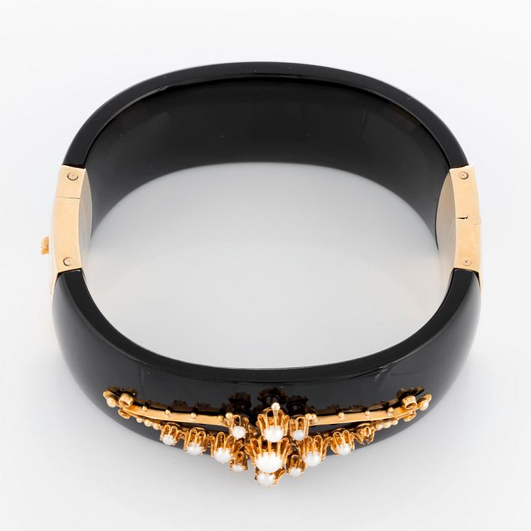 An onyx and 18K gold bracelet set with pearls.