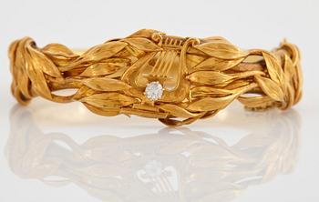 An 18K gold bangle set with an old-cut diamond.