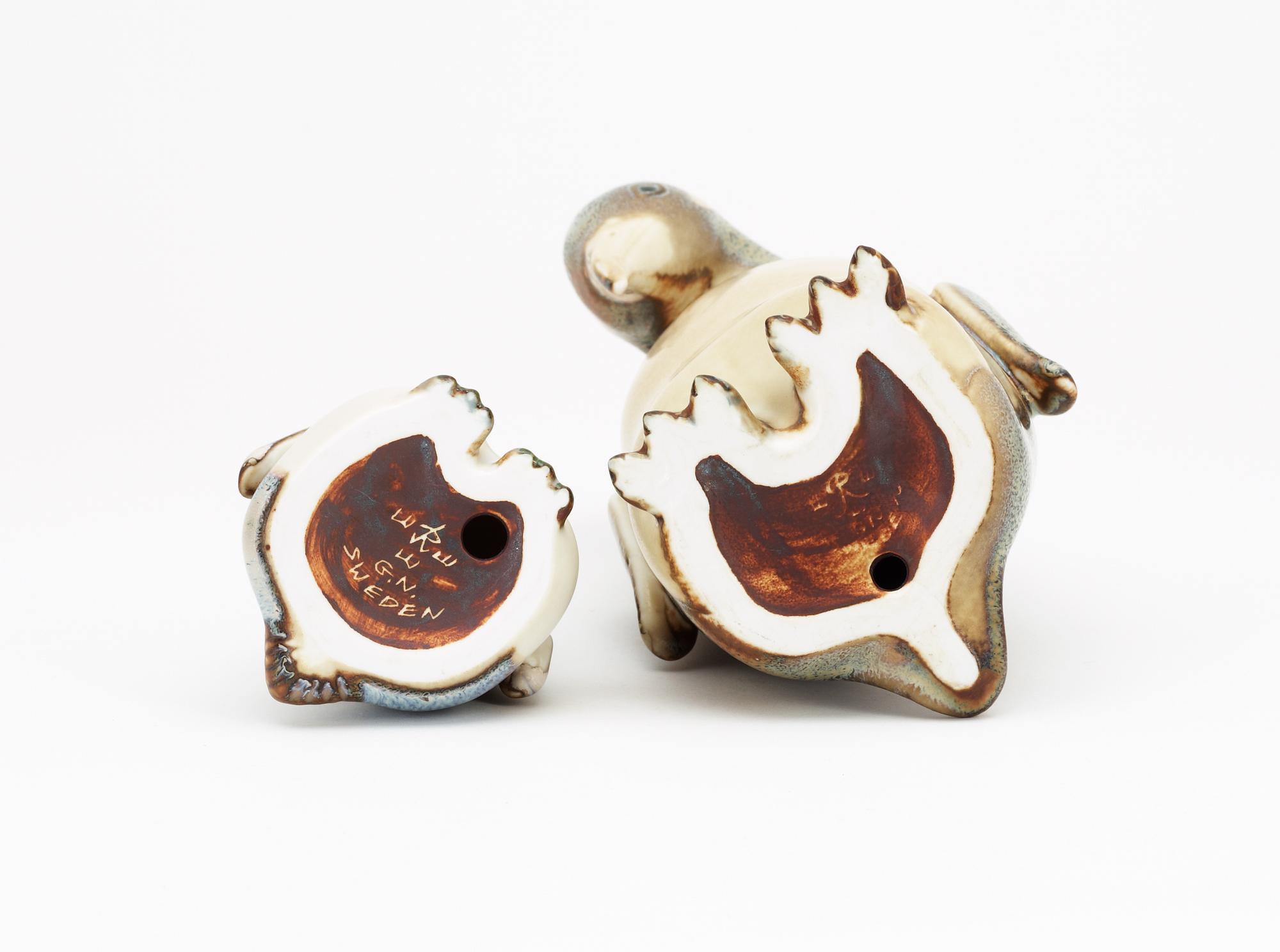 Two Gunnar Nylund stoneware figures depicting a penguin mother with child, Rörstrand.