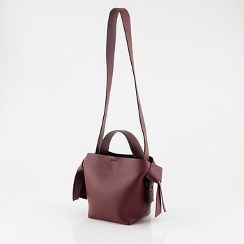 Acne Studios, a burgungy leather 'Musubi Mini' handbag.