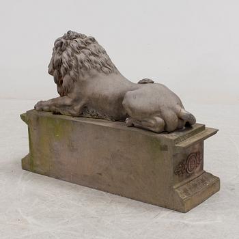 A SCULPTURE/ DECOR-ELEMENT, a lion on a plint, artificial stone, empire-style, late 1900s.