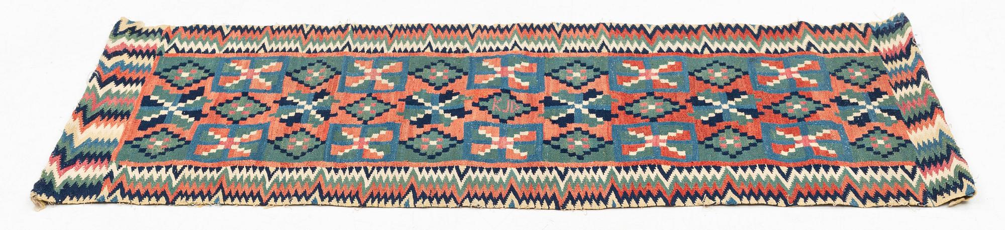 A carrige cushion, "Åttabladsstjärnor", flat weave, ca 46,5 x 104 cm, Scania, 1780 to 1820.