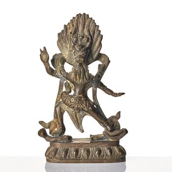 A bronze deity and a brass sacrificial bowl, Tibet, circa 1900.