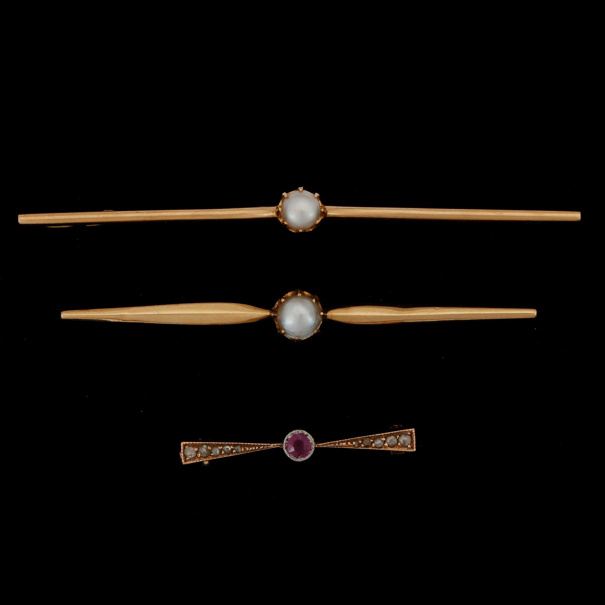 BROSCHNÅLAR, 2+1 st, 18k samt 14k guld, bl a en med rubin och rosenstenar, 1900-talets första hälft. Totalvikt ca 7,2 g.