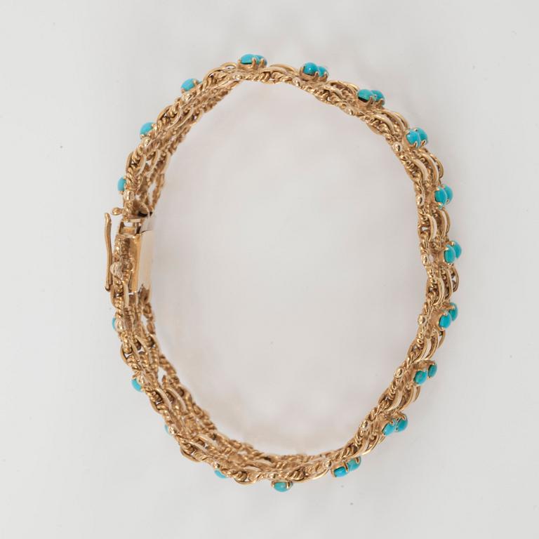 A gold and turquoise bracelet.