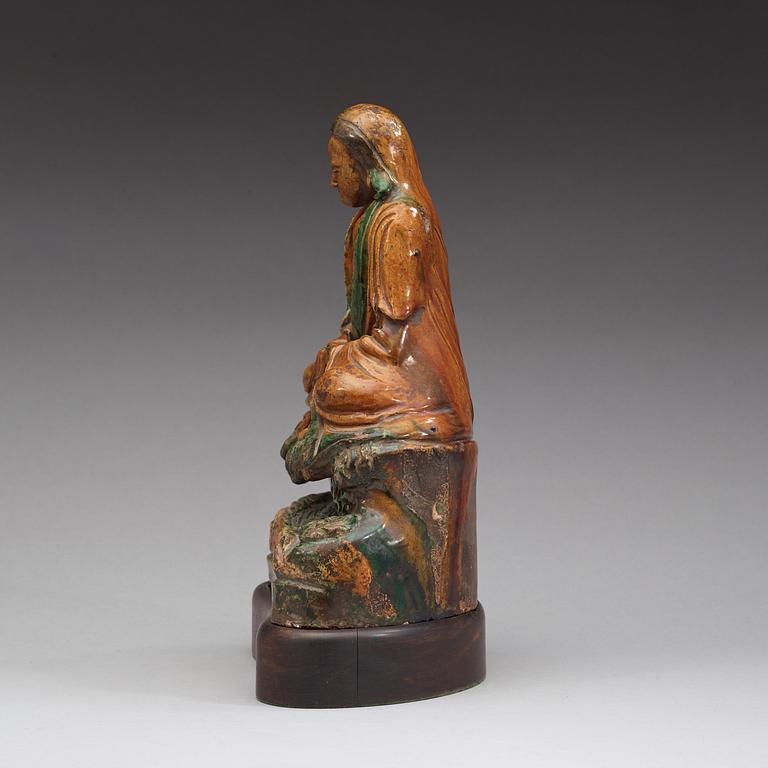 A seated green and yellow glazed deity, Ming dynasty (1368-1644).