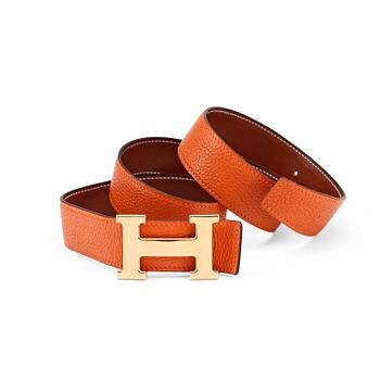 822. HERMÈS, a reversible belt, togo orange and brown with gold colored  H belt buckle.