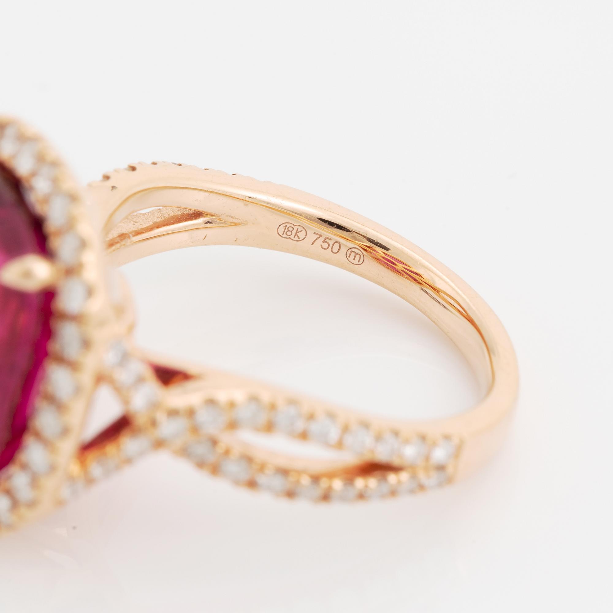 An 18K gold ring set with a faceted pink tourmaline and round brilliant-cut diamonds.