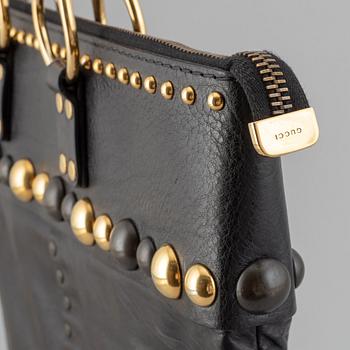 Gucci, a black leather handbag.