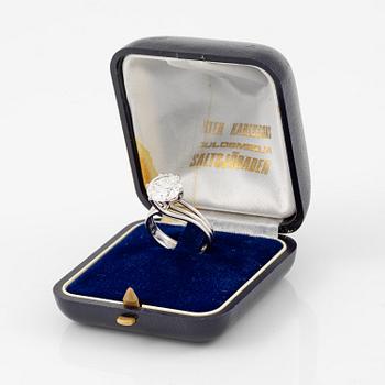 A ring in 18K white gold set with a round brilliant-cut diamond.