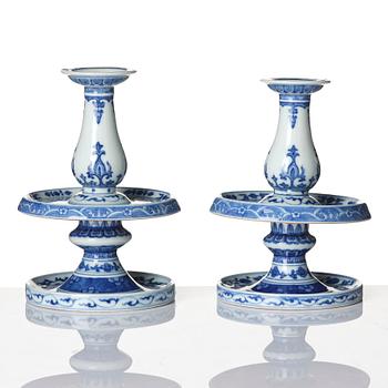 A pair of blue and white pricket candle sticks, with a poem, Qing dynasty with a Qianlong mark and of the period.