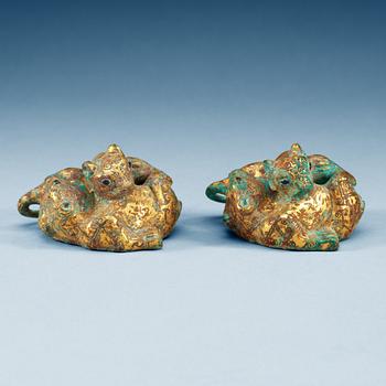 1828. A pair of gilt bronze archaistic weights.