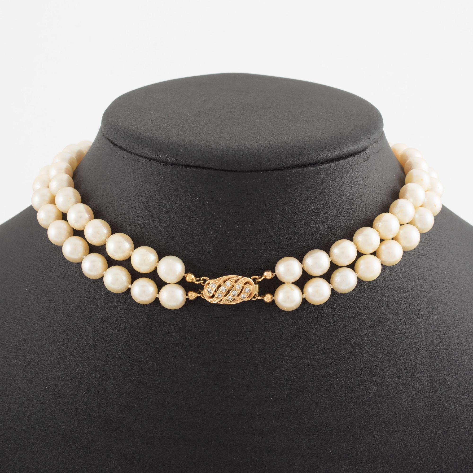 Necklace of two strands of cultured pearls, clasp with 18K gold lock set with eight-cut diamonds.
